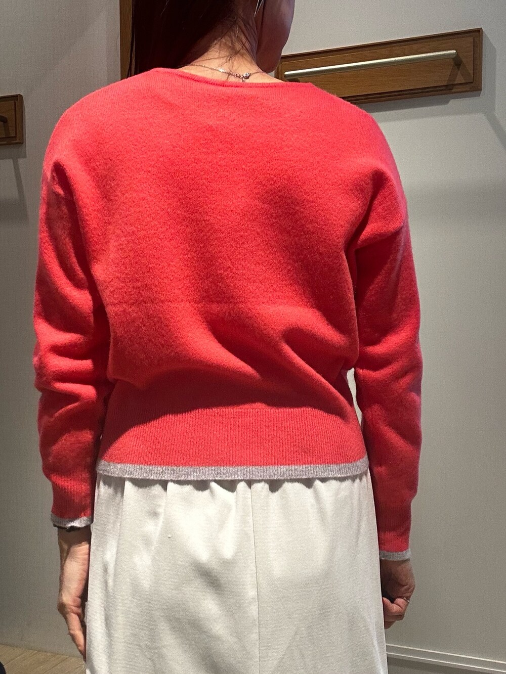 ピンク系のニット/セーター、ホワイト系のスカート、グレー系のダウンジャケット/コートを着用したレディースの冬コーディネートの6枚目の写真