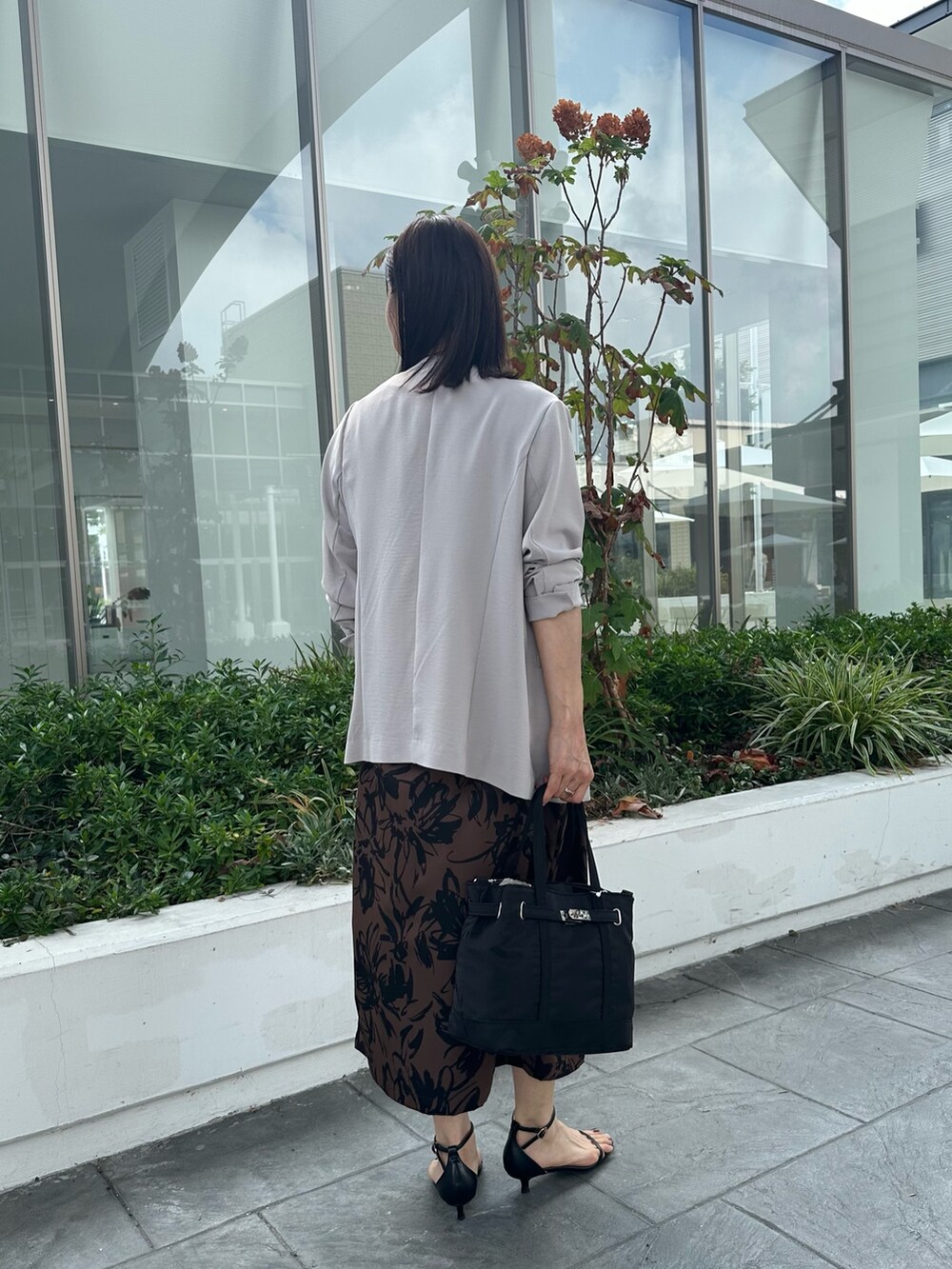 ベージュ系のワンピース、ブラック系のトートバッグ、ベージュ系のノーカラージャケットを着用したレディースの秋コーディネートの8枚目の写真