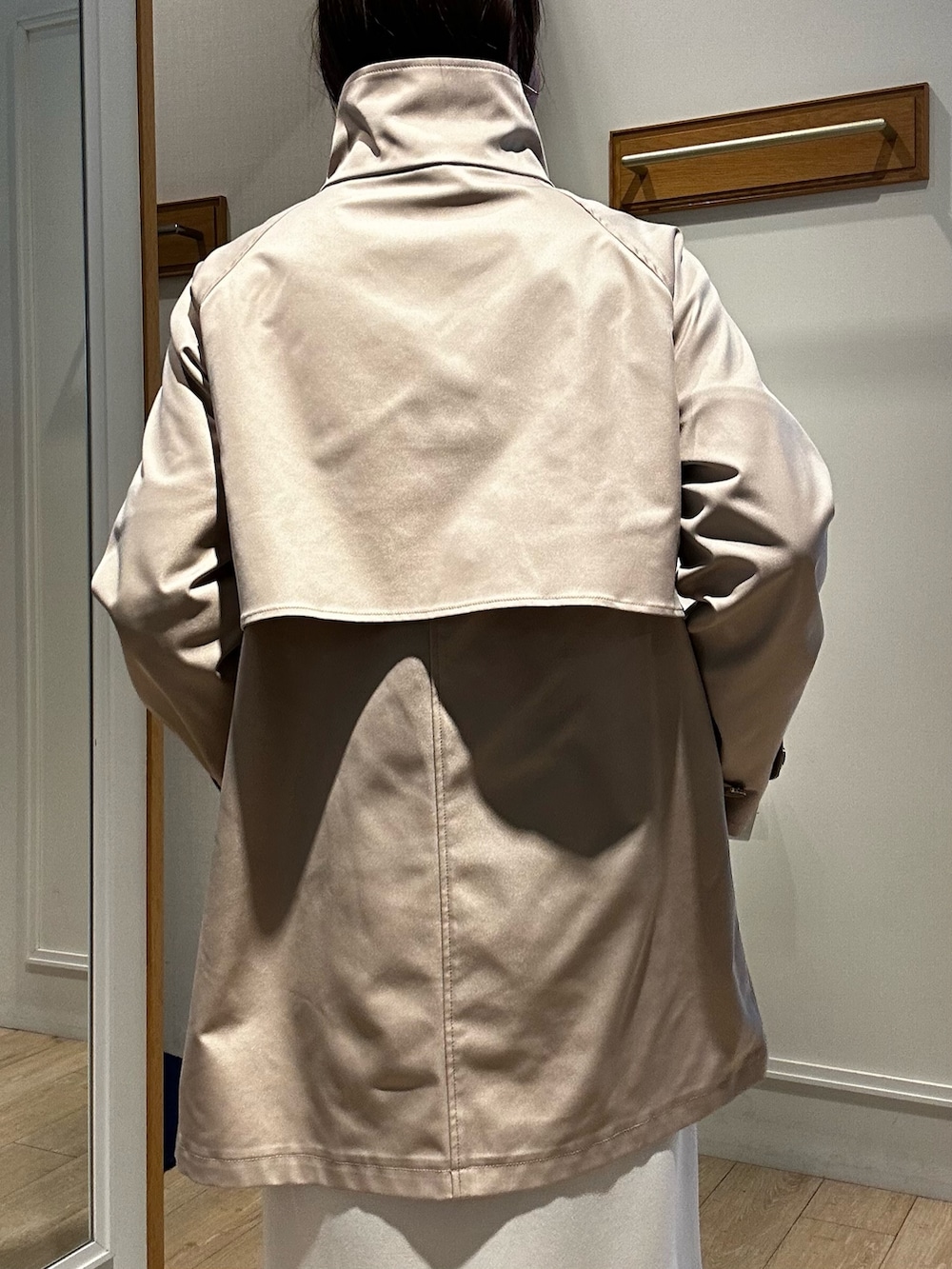 ベージュ系のその他アウター、ブラック系のニット/セーター、ホワイト系のスカートを着用したレディースの冬コーディネートの8枚目の写真