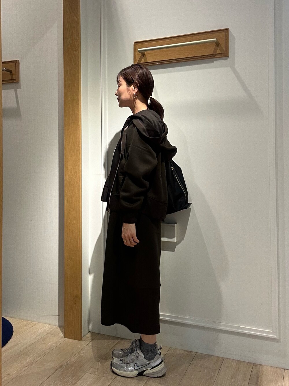 ブラウン系のパーカー、ブラウン系のスカート、ブラック系のショルダーバッグを着用したレディースの秋コーディネートの4枚目の写真