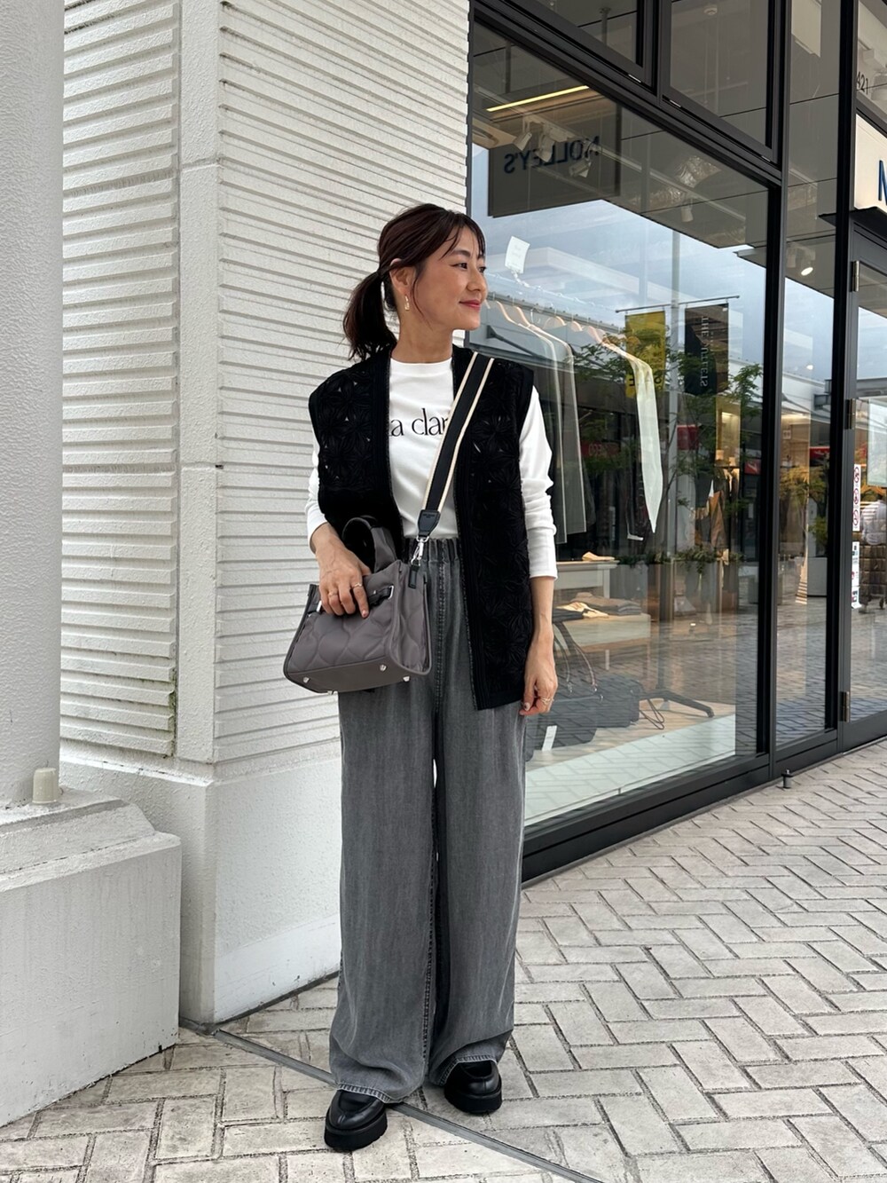 グレー系のデニムパンツ、ブラック系のニット/セーター、グレー系のトートバッグを着用したレディースの秋コーディネートの7枚目の写真