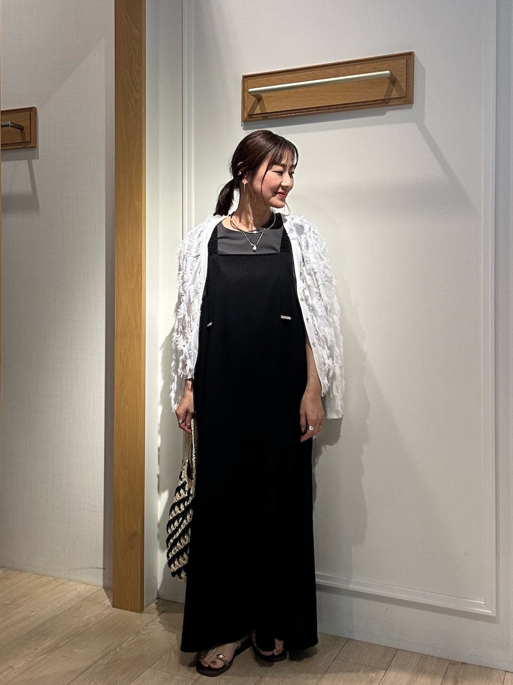 ホワイト系のカーディガン/ボレロ、ブラック系のワンピース、ゴールド系のネックレスを着用したレディースの夏コーディネートの3枚目の写真