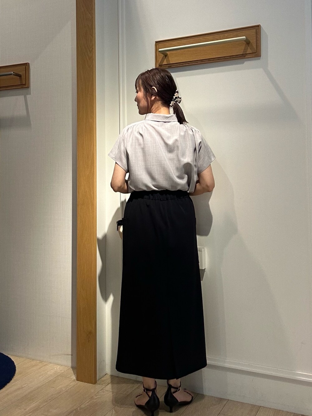 グレー系のシャツ/ブラウス、ブラック系のスカート、ブラック系のバックパック/リュックを着用したレディースの夏コーディネートの3枚目の写真