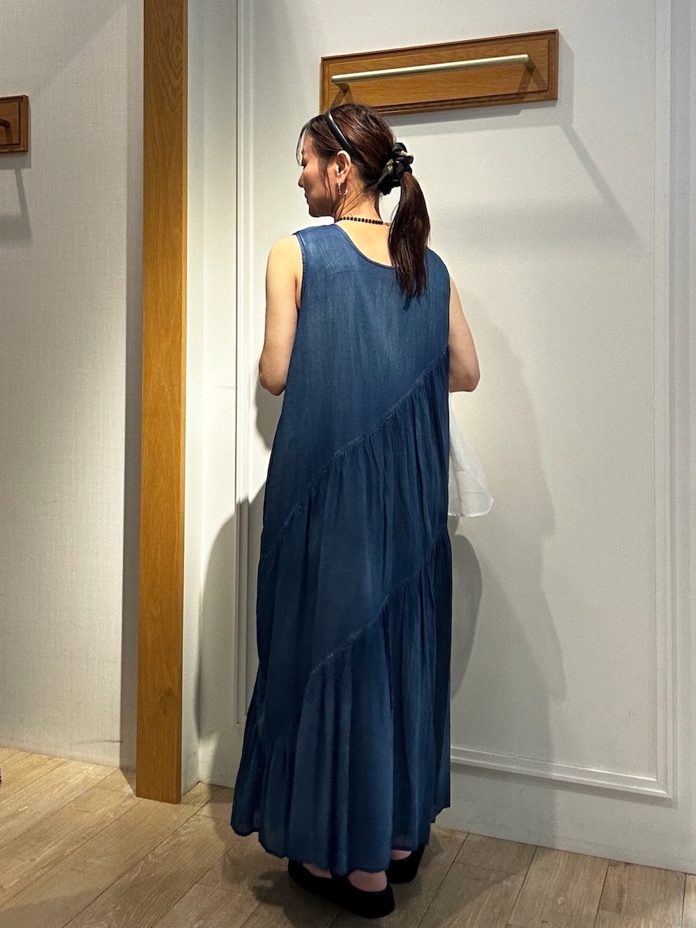 ブルー系のワンピース、ホワイト系のカーディガン/ボレロ、ブラック系のネックレスを着用したレディースの夏コーディネートの2枚目の写真