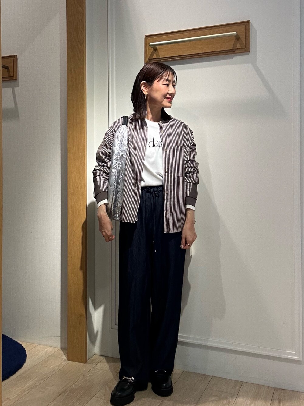 ブラウン系のシャツ/ブラウス、ブルー系のデニムパンツ、シルバー系のトートバッグを着用したレディースの秋コーディネートの5枚目の写真