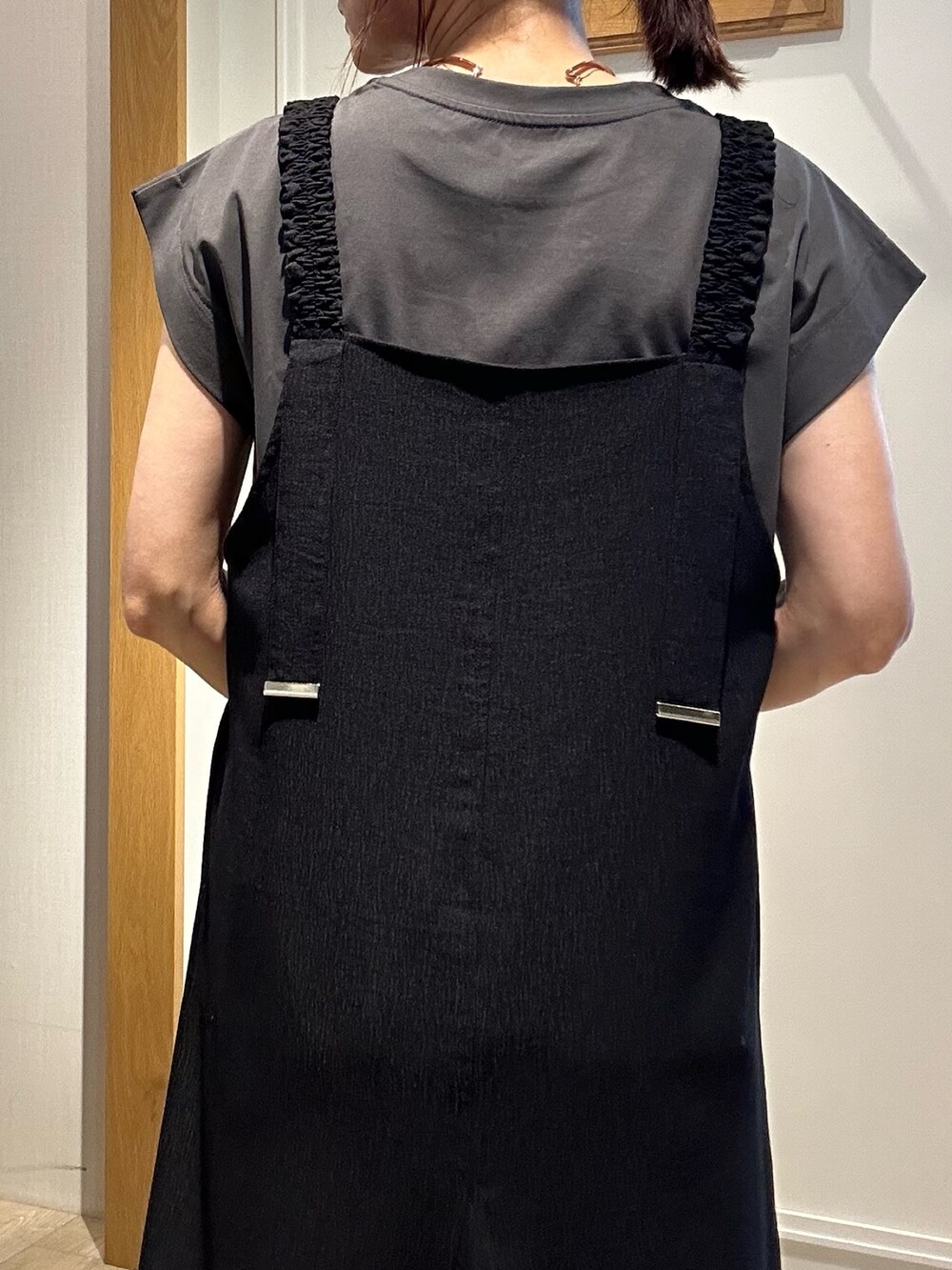 ブラック系のワンピース、ホワイト系のカーディガン/ボレロ、ゴールド系のネックレスを着用したレディースの夏コーディネートの7枚目の写真