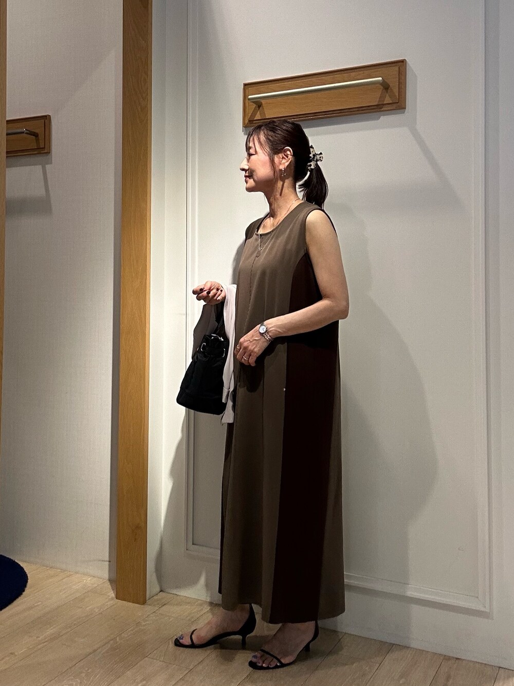 ブラウン系のワンピース、ブラック系のサンダル、ベージュ系のテーラードジャケットを着用したレディースの夏コーディネートの2枚目の写真