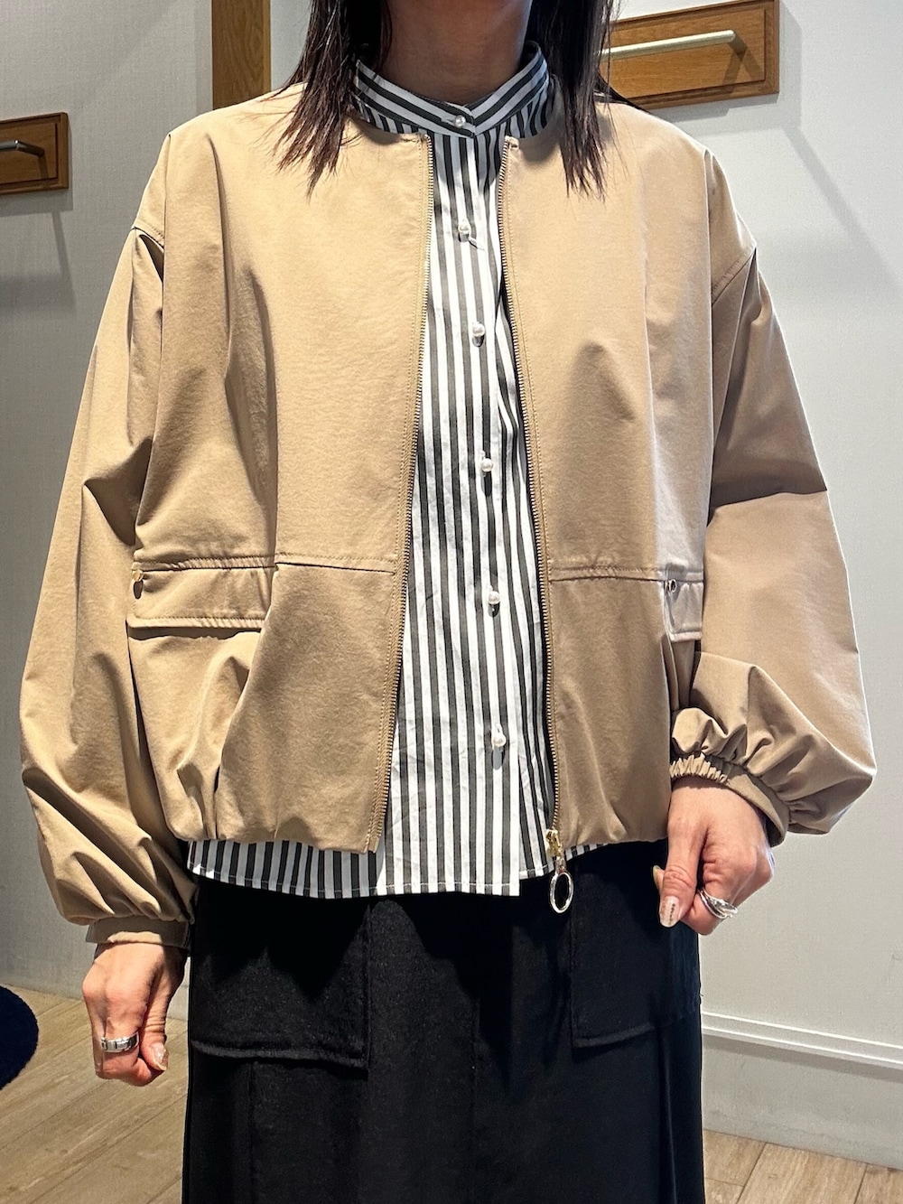 ブラック系のスカート、グレー系のシャツ/ブラウス、イエロー系のブルゾンを着用したレディースの春コーディネートの4枚目の写真