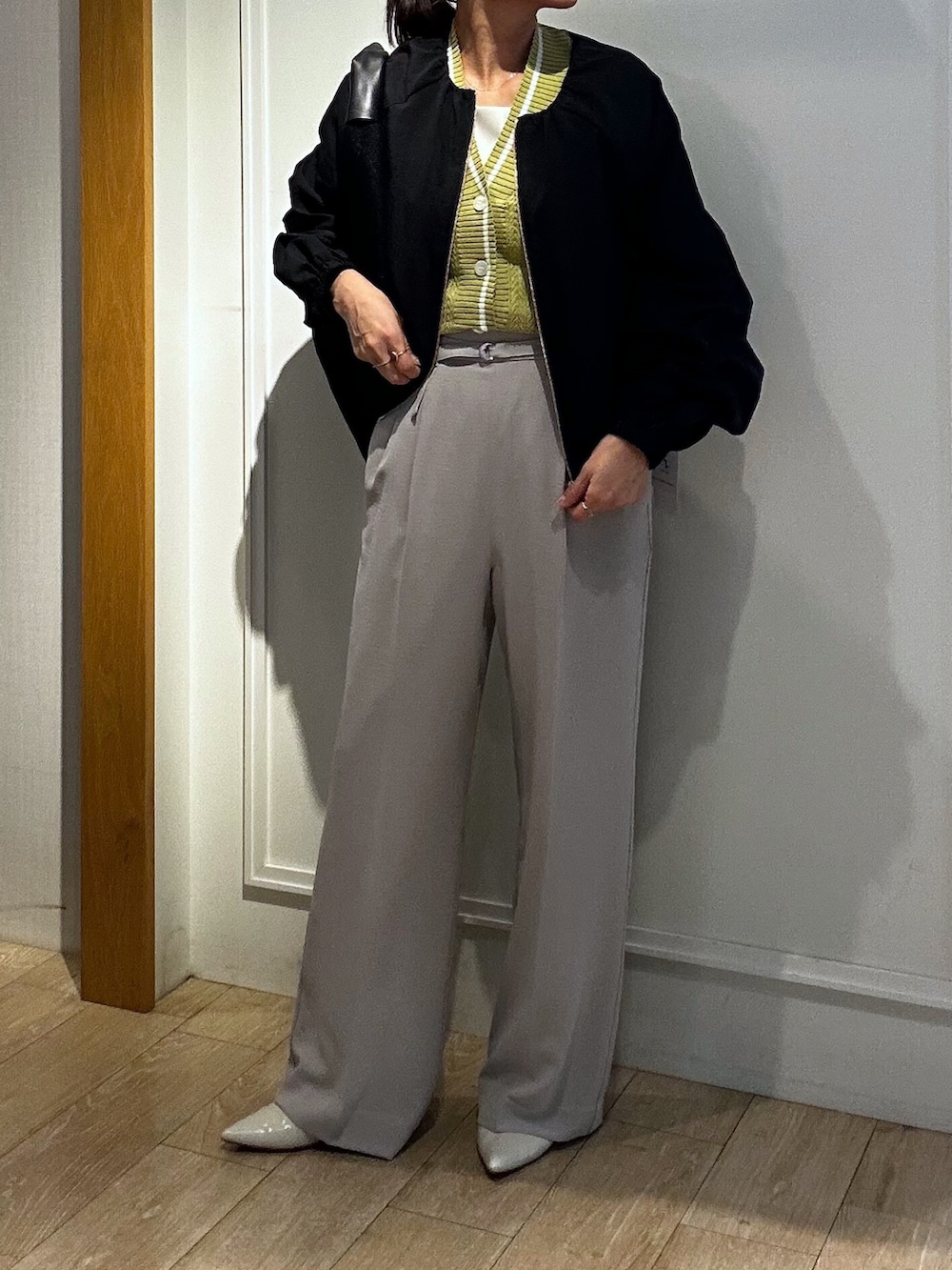 ベージュ系のその他パンツ、イエロー系のカーディガン/ボレロ、ブラック系のブルゾンを着用したレディースの春コーディネートの8枚目の写真