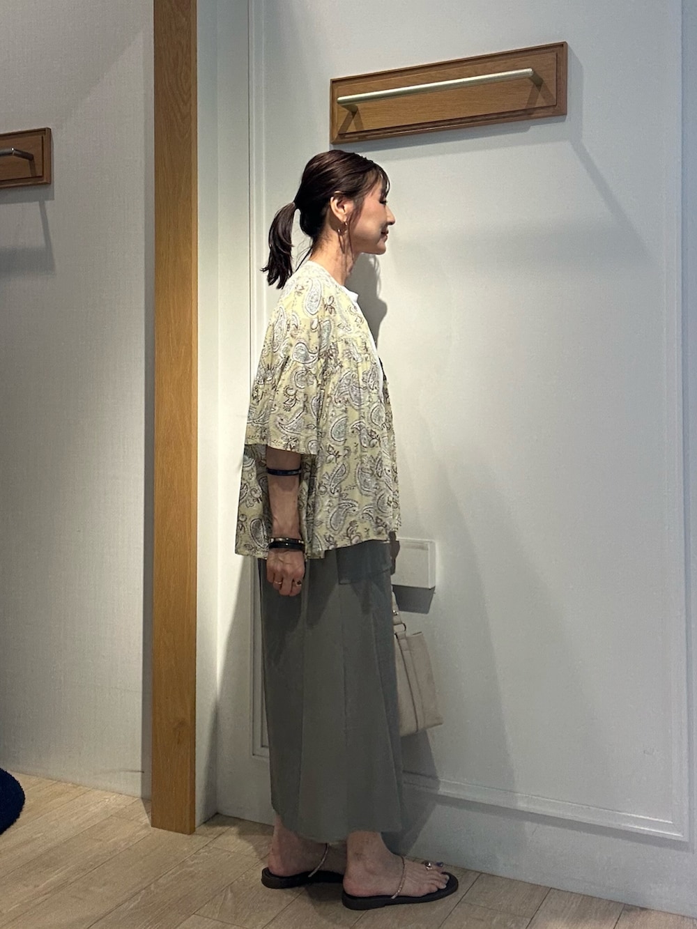 グリーン系のスカート、ブラウン系のシャツ/ブラウス、ホワイト系のシャツ/ブラウスを着用したレディースの夏コーディネートの4枚目の写真