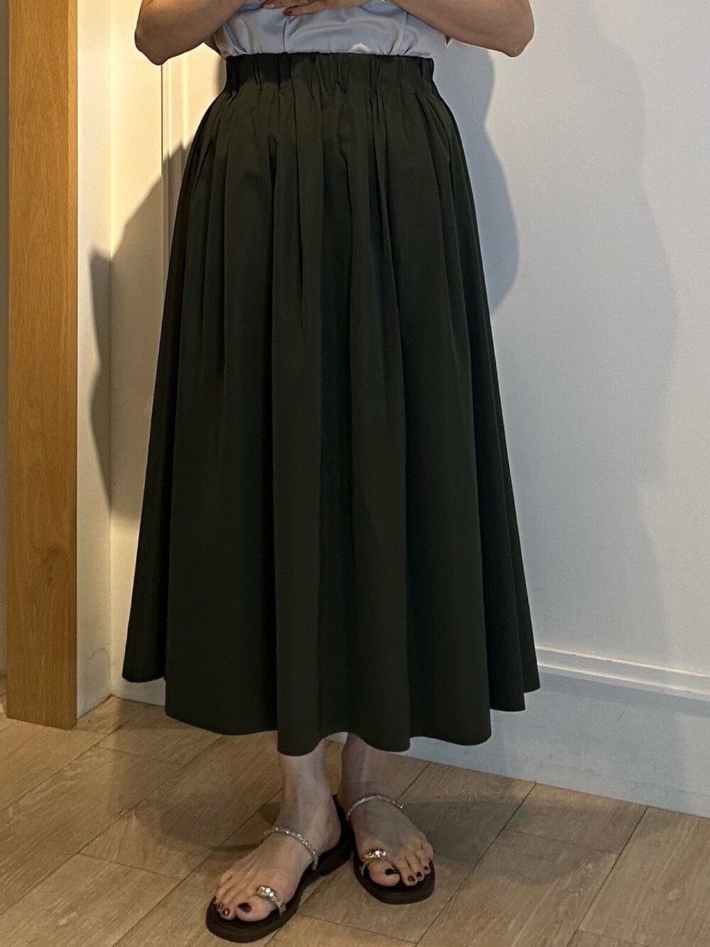 グリーン系のスカート、グレー系のTシャツ/カットソーを着用したレディースの春コーディネートの8枚目の写真