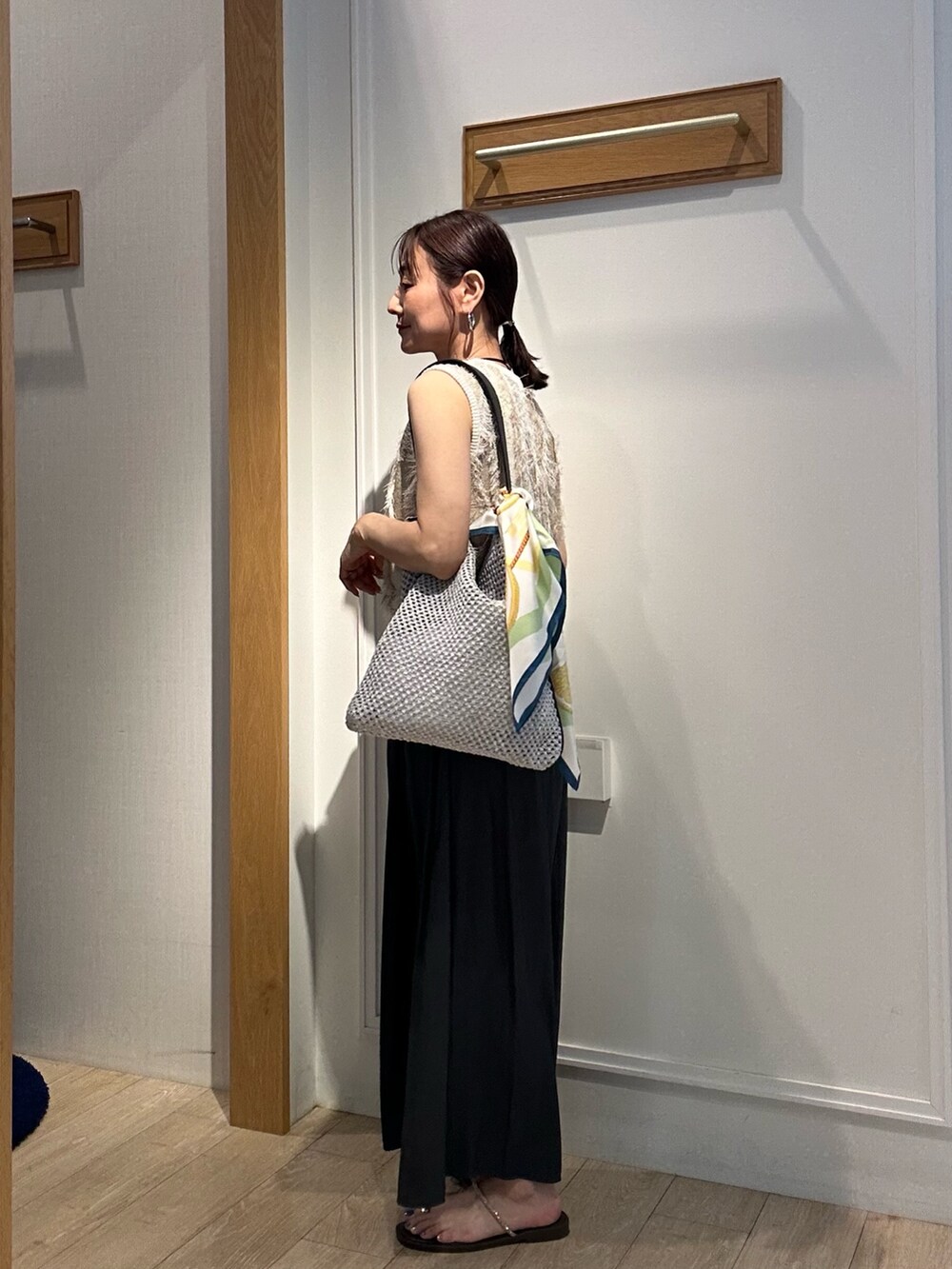 ベージュ系のニット/セーター、グレー系のその他パンツ、グレー系のショルダーバッグを着用したレディースの夏コーディネートの6枚目の写真