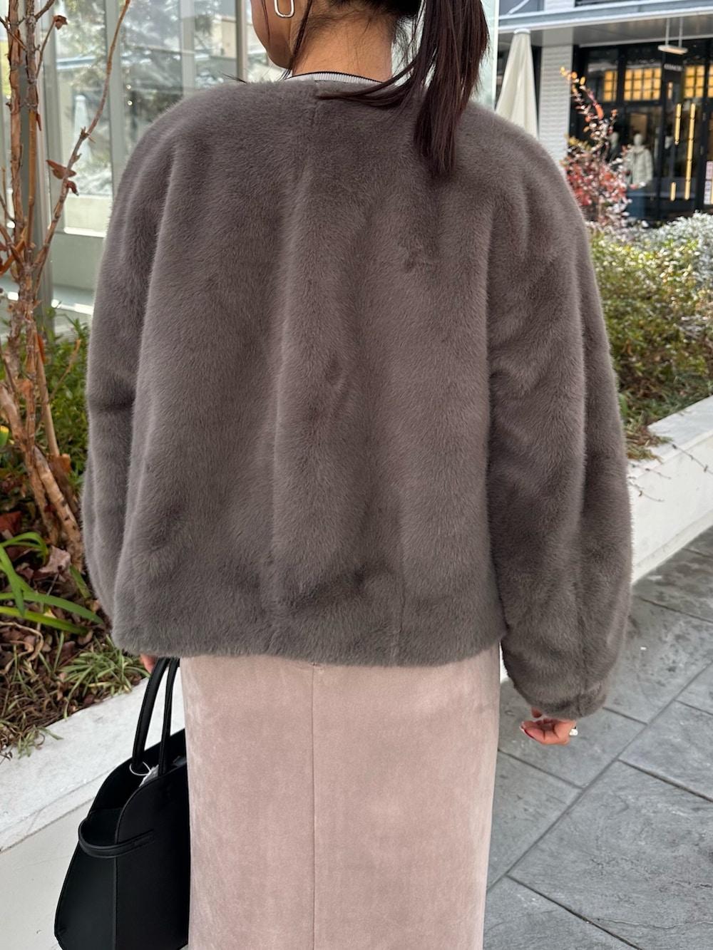 グレー系のブルゾン、グレー系のニット/セーター、ピンク系のスカートを着用したレディースの冬コーディネートの6枚目の写真