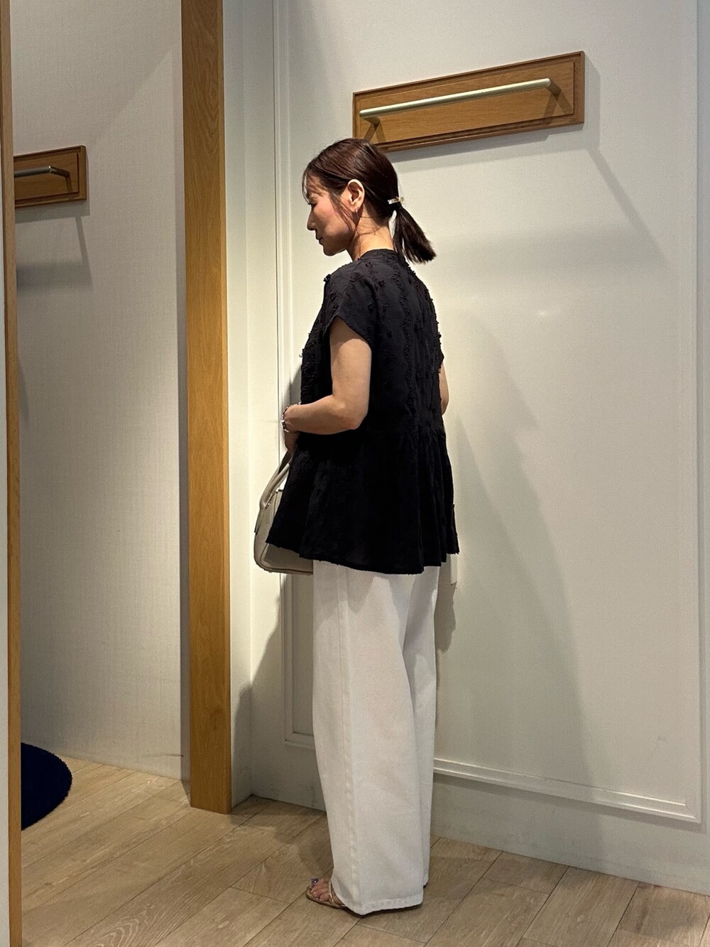 ブラック系のシャツ/ブラウス、ホワイト系のデニムパンツ、ベージュ系のボストンバッグを着用したレディースの夏コーディネートの3枚目の写真