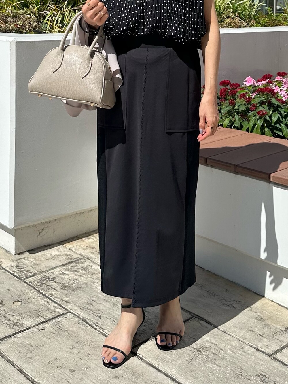 ブラック系のシャツ/ブラウス、ブラック系のスカート、ベージュ系のボストンバッグを着用したレディースの夏コーディネートの7枚目の写真