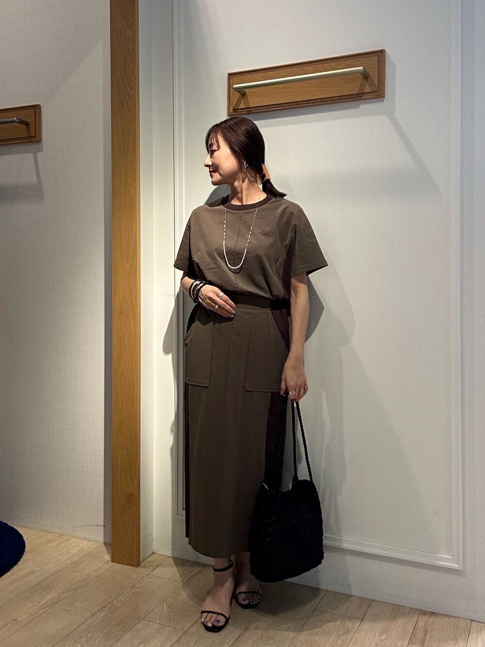 ブラウン系のTシャツ/カットソー、ブラウン系のスカート、ブラック系のサンダルを着用したレディースの夏コーディネートの5枚目の写真