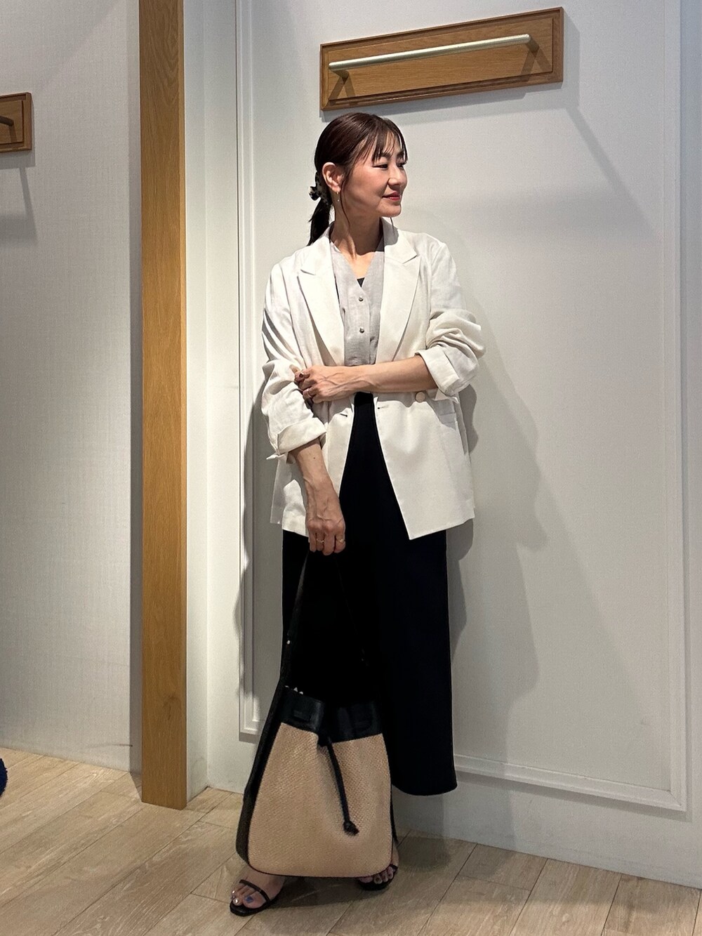 ホワイト系のテーラードジャケット、ベージュ系のシャツ/ブラウス、ブラック系のスカートを着用したレディースの夏コーディネートの5枚目の写真