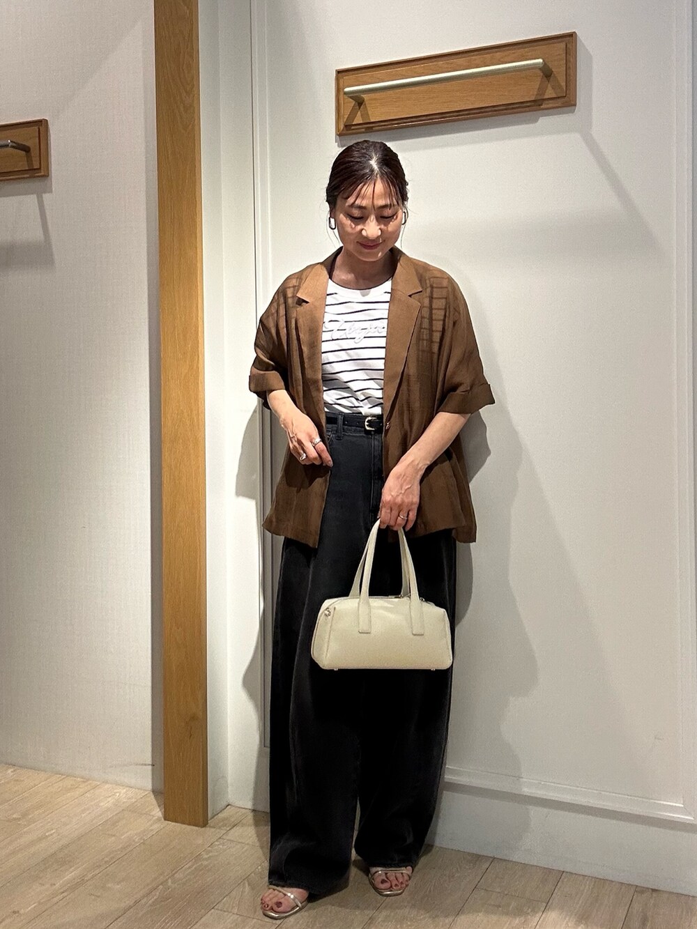 ホワイト系のTシャツ/カットソー、ホワイト系のボストンバッグ、ブラウン系のテーラードジャケットを着用したレディースの夏コーディネートの4枚目の写真