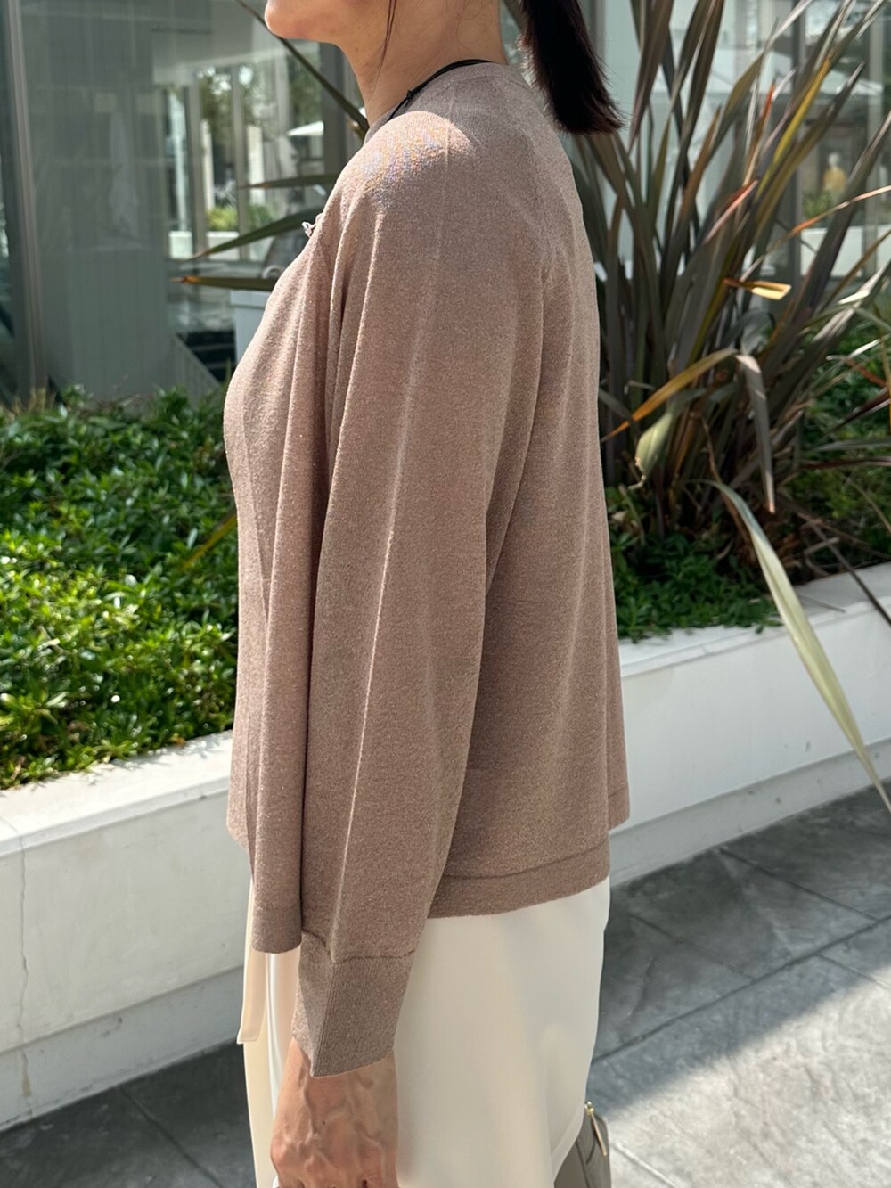 ブラウン系のニット/セーター、ホワイト系のその他パンツ、ベージュ系のボストンバッグを着用したレディースの夏コーディネートの7枚目の写真