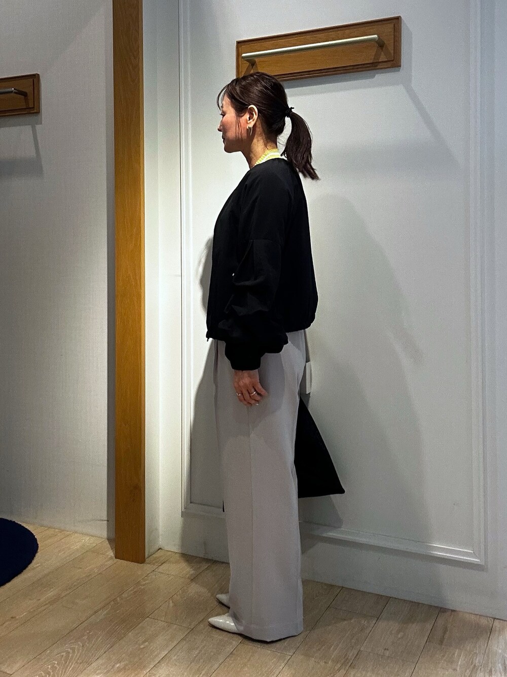 ベージュ系のその他パンツ、イエロー系のカーディガン/ボレロ、ブラック系のブルゾンを着用したレディースの春コーディネートの4枚目の写真