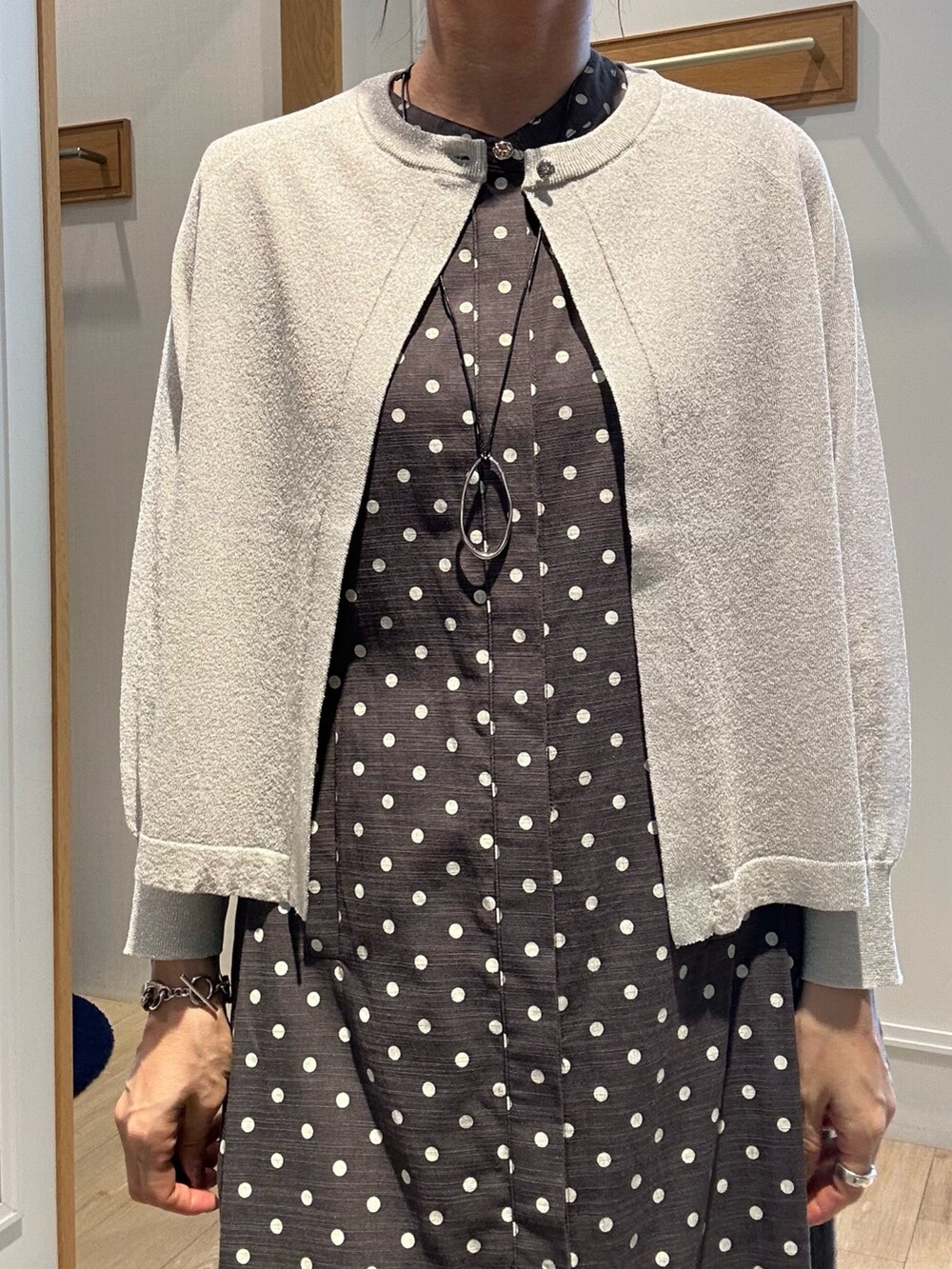 シルバー系のニット/セーター、グレー系のワンピース、ベージュ系のボストンバッグを着用したレディースの夏コーディネートの6枚目の写真