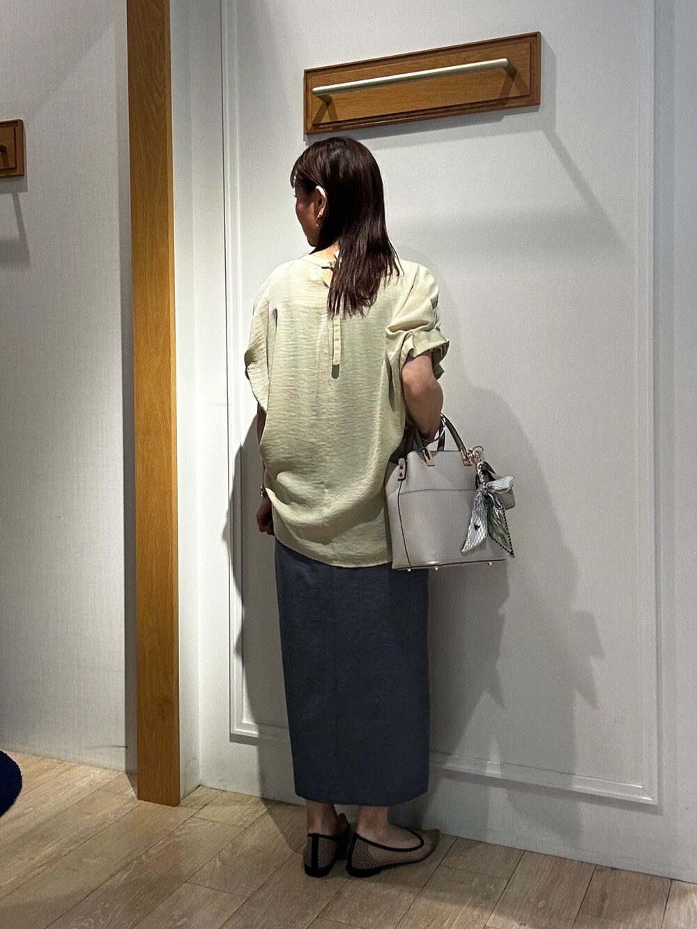 イエロー系のシャツ/ブラウス、ブルー系のスカート、グレー系のTシャツ/カットソーを着用したレディースの春コーディネートの3枚目の写真