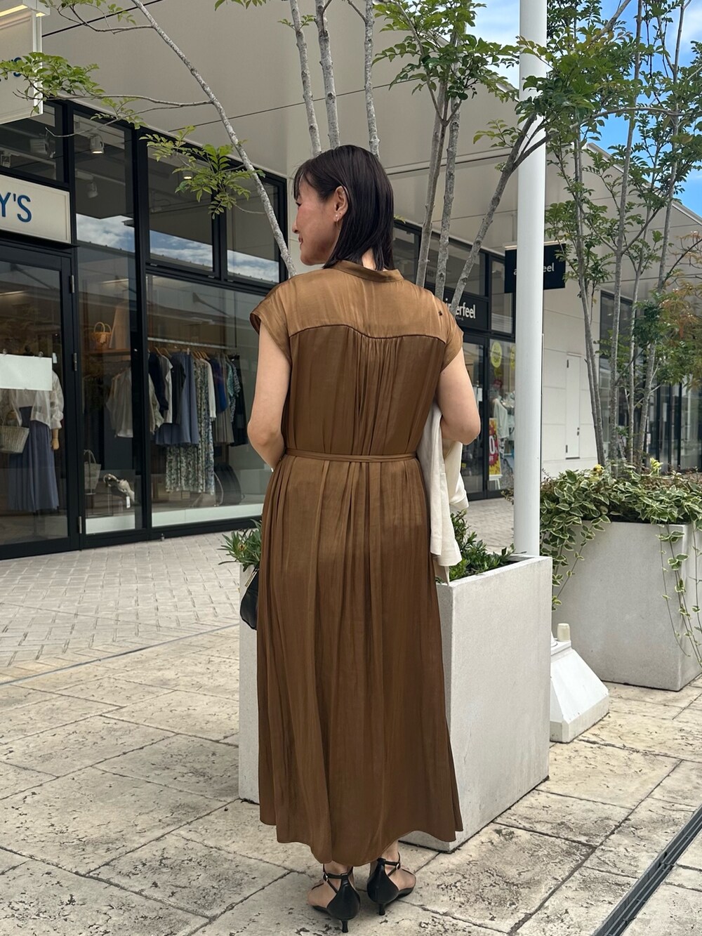 ブラウン系のワンピース、ブラック系のボストンバッグ、ブラック系のサンダルを着用したレディースの夏コーディネートの3枚目の写真