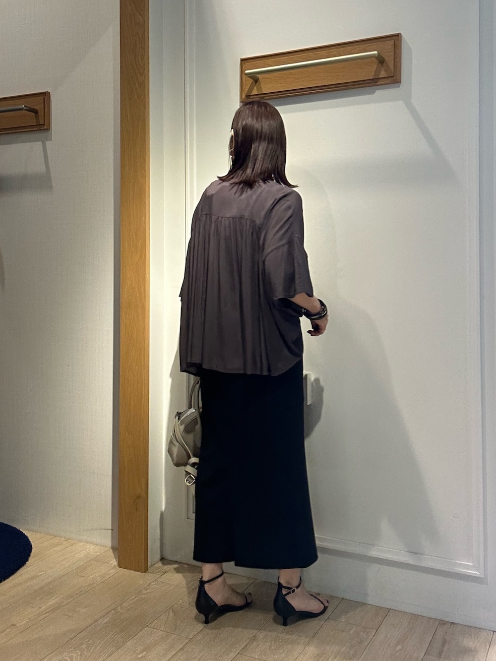 グレー系のシャツ/ブラウス、ブラック系のスカート、ベージュ系のボストンバッグを着用したレディースの夏コーディネートの5枚目の写真