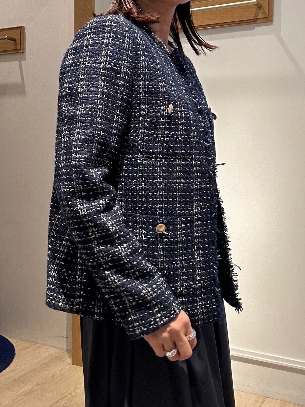 ブルー系のノーカラージャケット、ホワイト系のTシャツ/カットソー、ベージュ系のスカートを着用したレディースの冬コーディネートの6枚目の写真