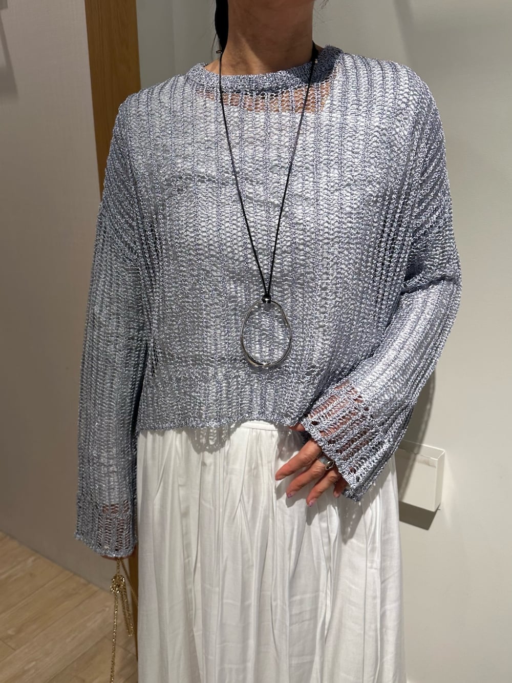 ブルー系のニット/セーター、ホワイト系のスカート、ホワイト系のTシャツ/カットソーを着用したレディースの冬コーディネートの3枚目の写真