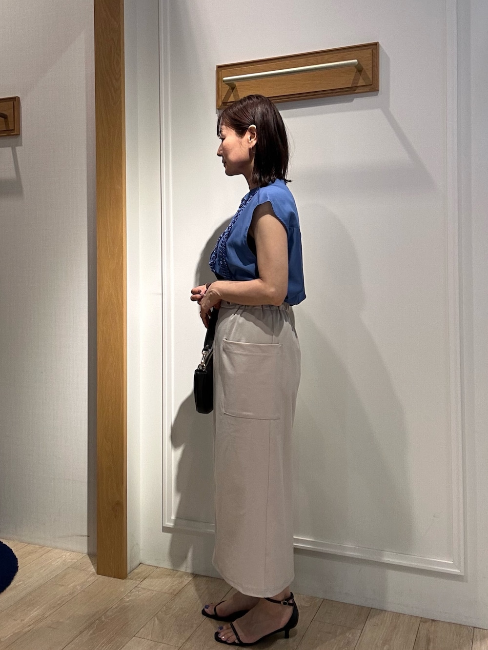 ブルー系のシャツ/ブラウス、ベージュ系のスカート、ブラック系のサンダルを着用したレディースの夏コーディネートの2枚目の写真