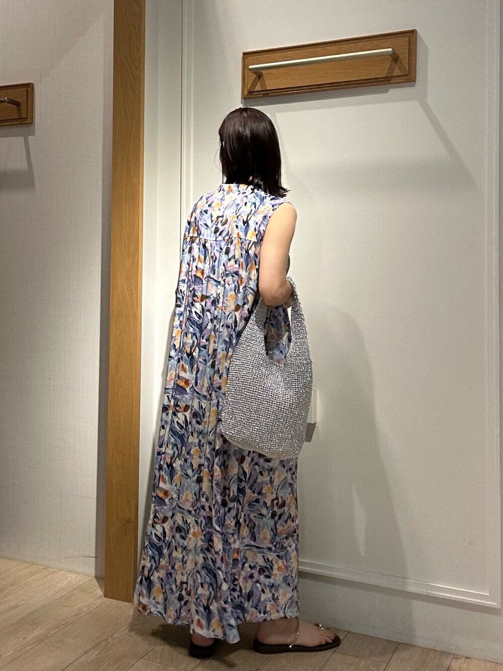 ブルー系のワンピース、グレー系のニット/セーター、ブラウン系のサンダルを着用したレディースの夏コーディネートの2枚目の写真