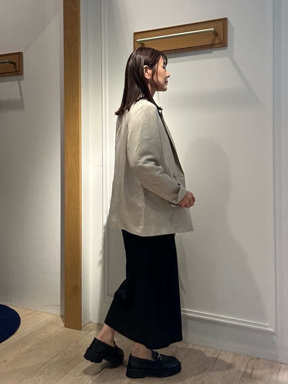 ベージュ系のテーラードジャケット、グリーン系のシャツ/ブラウス、ブラック系のスカートを着用したレディースの春コーディネートの2枚目の写真