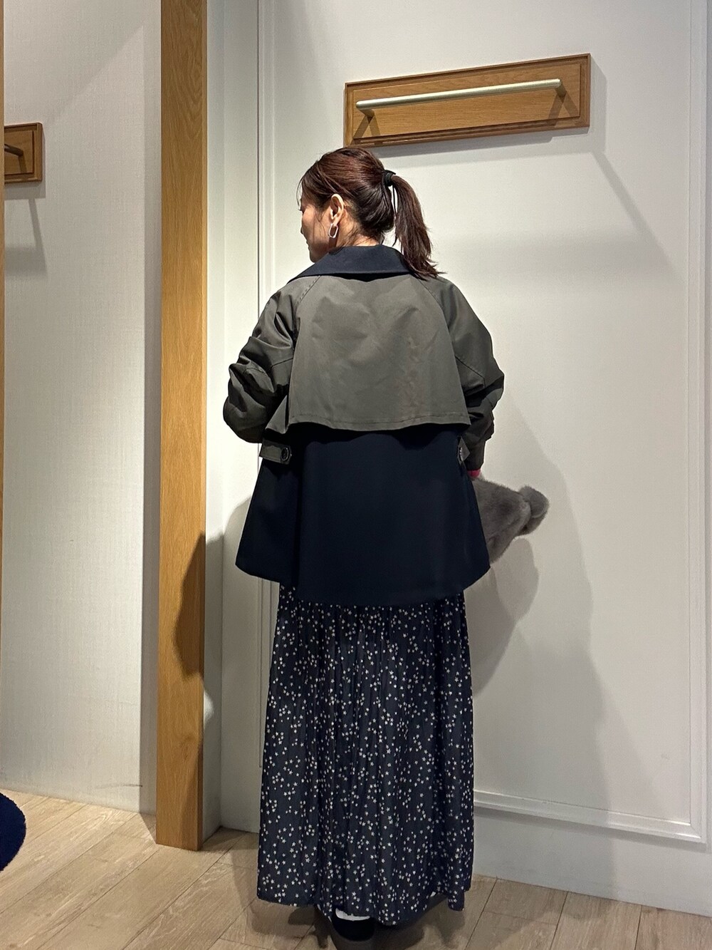 グレー系のトレンチコート、ピンク系のニット/セーターを着用したレディースの秋コーディネートの3枚目の写真