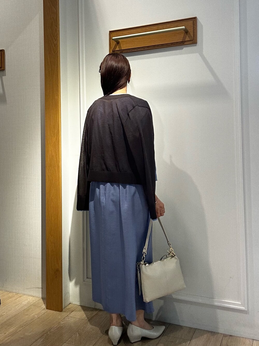 ブルー系のワンピース、ブラウン系のカーディガン/ボレロ、ホワイト系のショルダーバッグを着用したレディースの春コーディネートの6枚目の写真