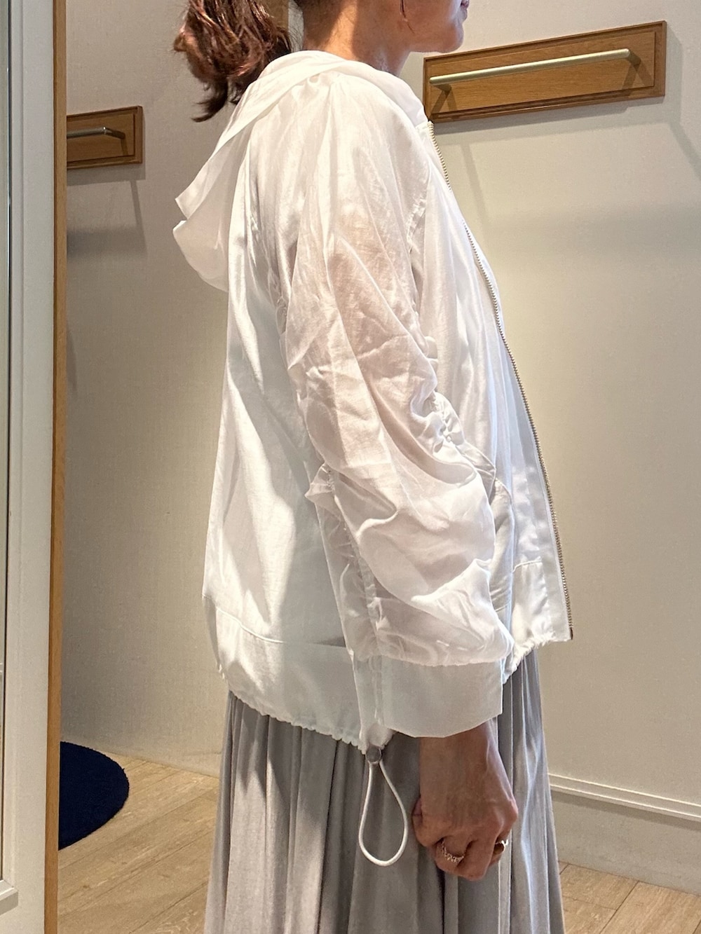 ベージュ系のスカート、ホワイト系のブルゾン、ホワイト系のTシャツ/カットソーを着用したレディースの春コーディネートの5枚目の写真