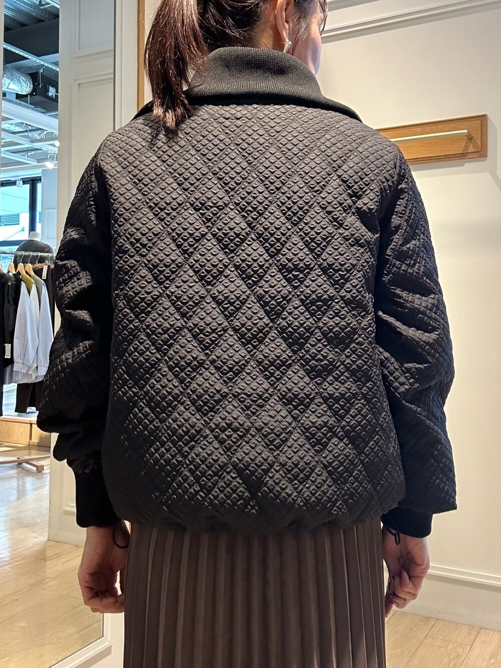 ブラウン系のブルゾン、ホワイト系のニット/セーター、ブラウン系のスカートを着用したレディースの秋コーディネートの7枚目の写真