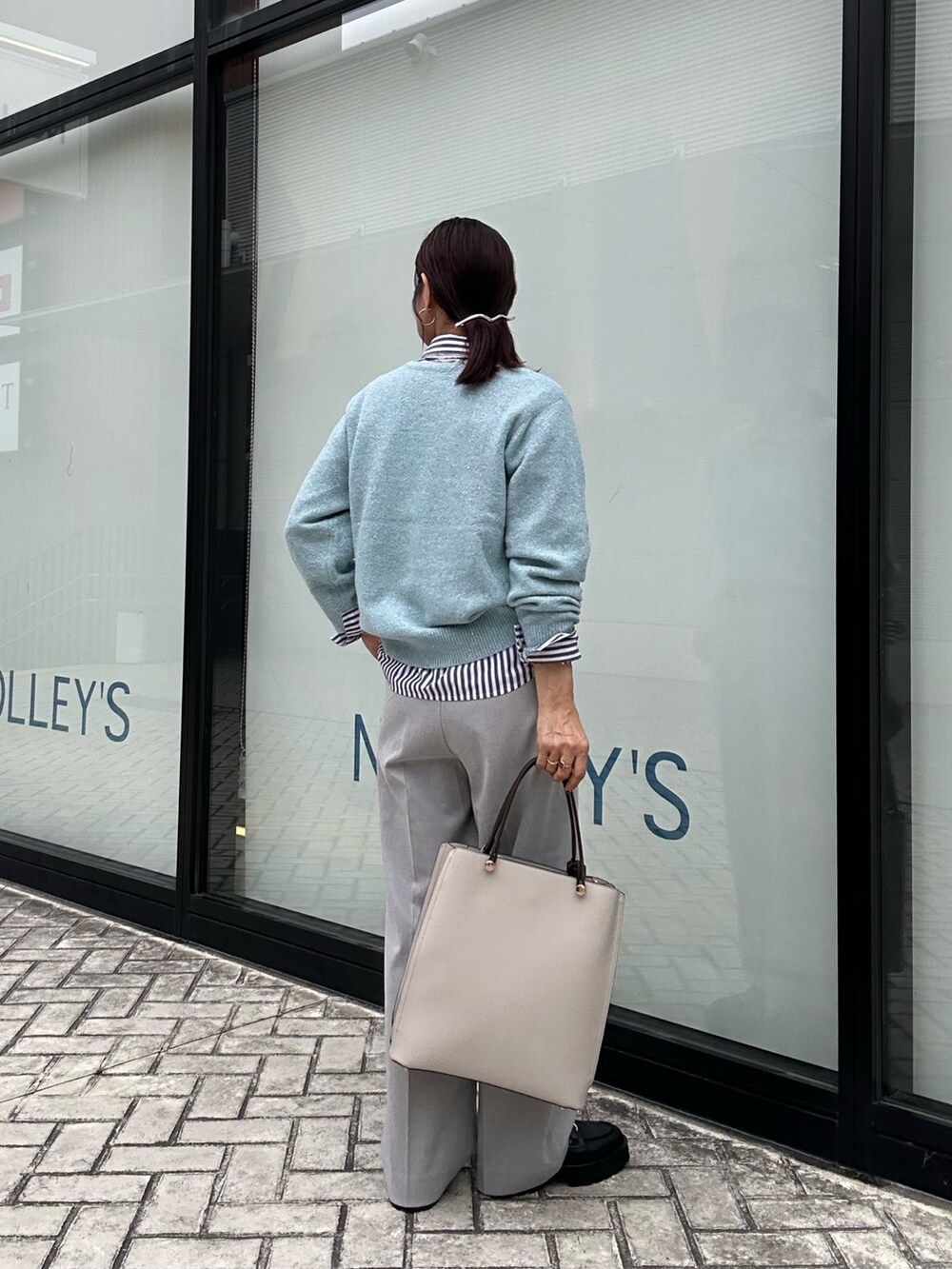 ブルー系のニット/セーター、グレー系のその他パンツ、ブラック系のシャツ/ブラウスを着用したレディースの秋コーディネートの3枚目の写真