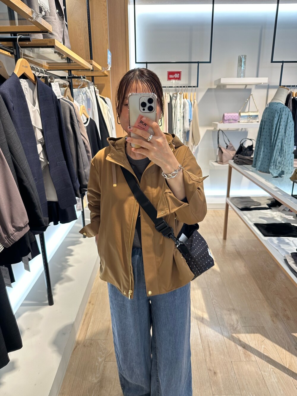 グレー系のTシャツ/カットソー、ブルー系のデニムパンツ、ブラウン系のブルゾンを着用したレディースの秋コーディネートの7枚目の写真