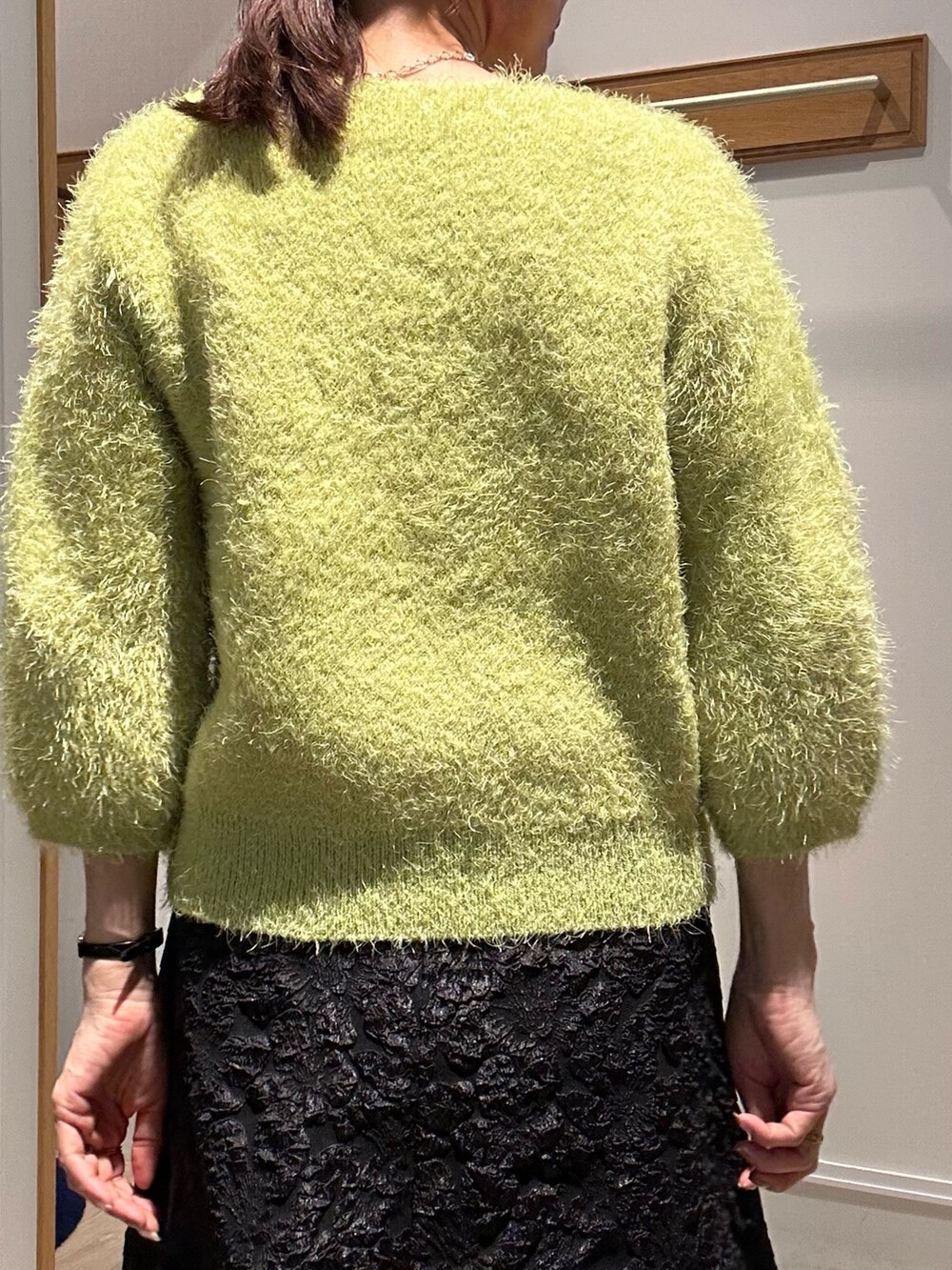 グリーン系のニット/セーター、グレー系のスカート、イエロー系のブルゾンを着用したレディースの秋コーディネートの7枚目の写真