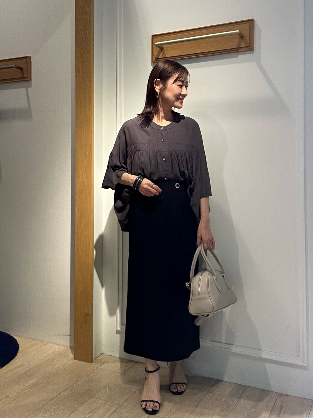 グレー系のシャツ/ブラウス、ブラック系のスカート、ベージュ系のボストンバッグを着用したレディースの夏コーディネートの6枚目の写真
