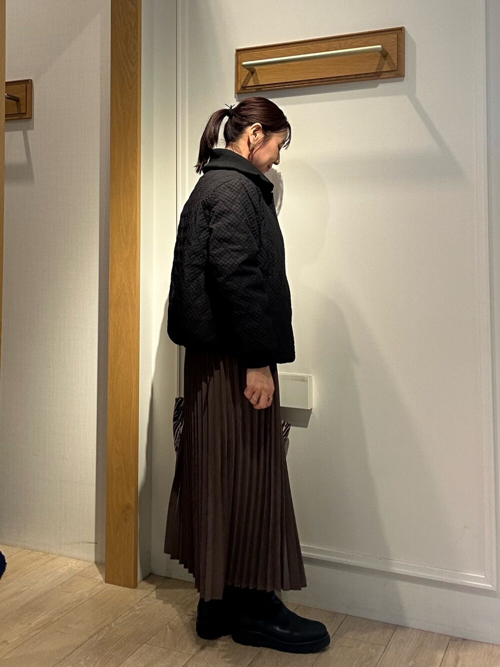 ブラウン系のブルゾン、ホワイト系のニット/セーター、ブラウン系のスカートを着用したレディースの秋コーディネートの3枚目の写真