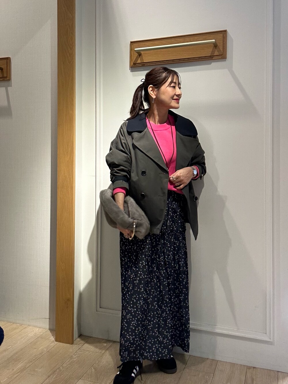 グレー系のトレンチコート、ピンク系のニット/セーターを着用したレディースの秋コーディネートの4枚目の写真