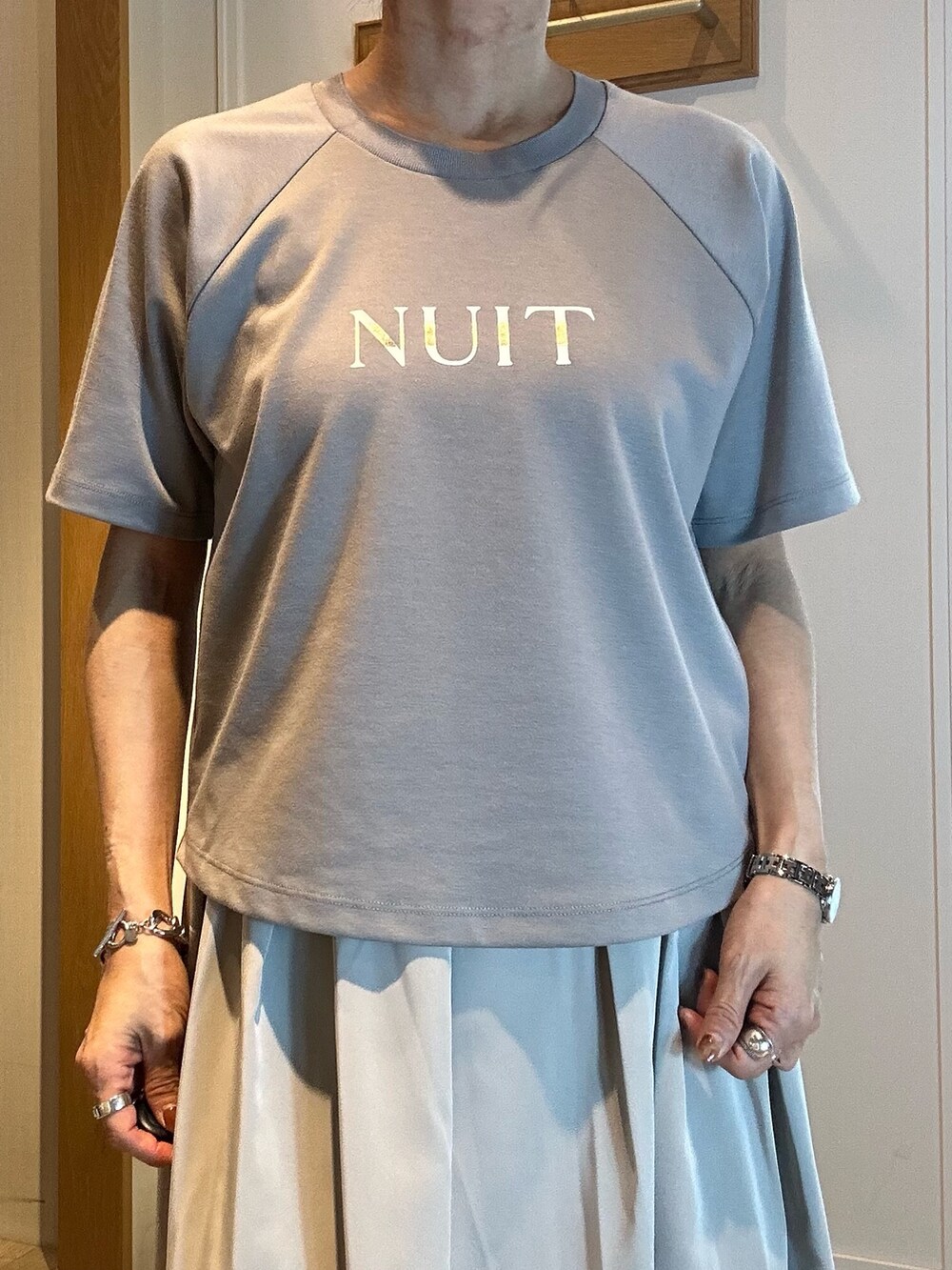 グリーン系のスカート、グレー系のTシャツ/カットソーを着用したレディースの春コーディネートの4枚目の写真