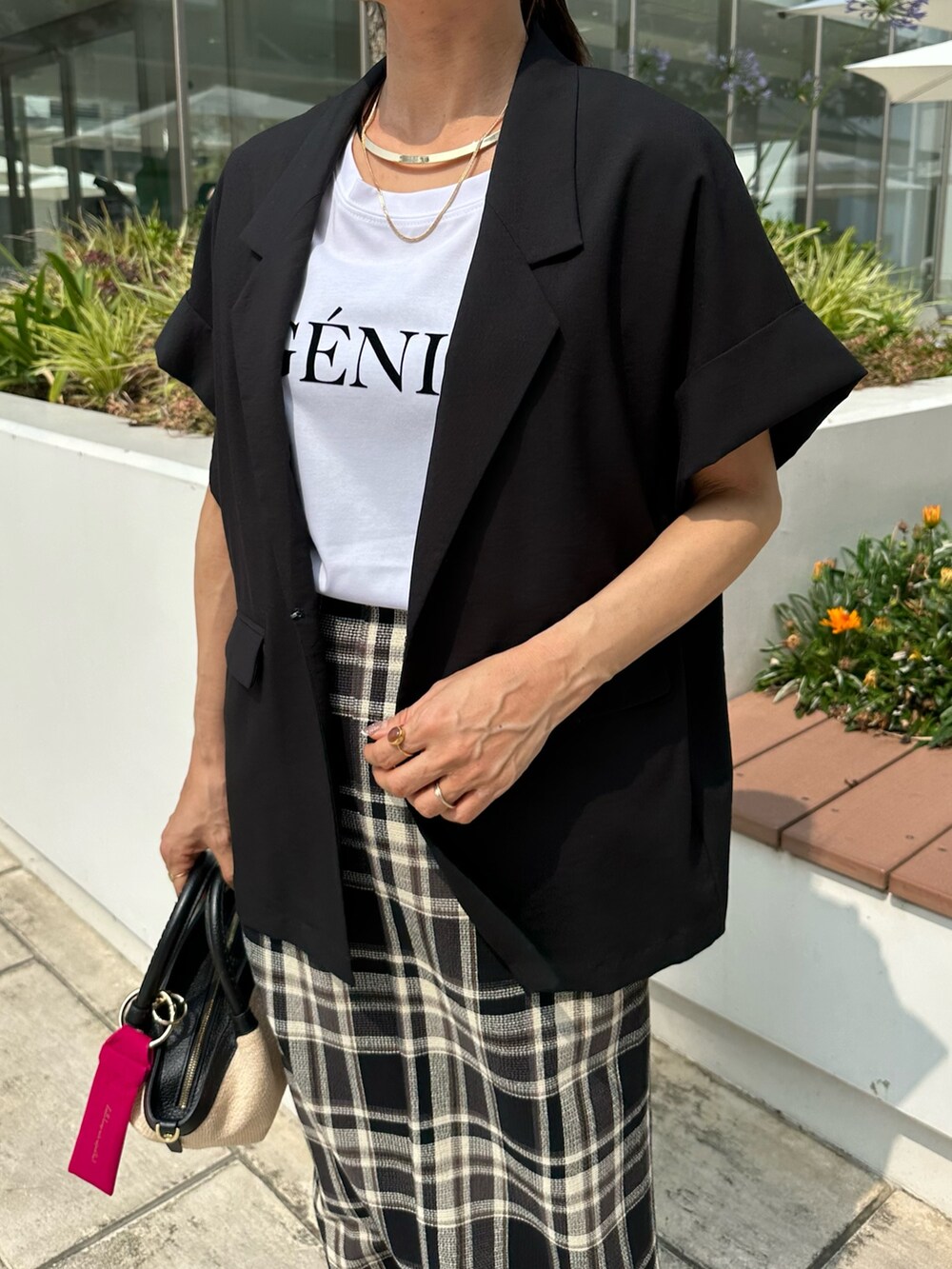 ブラック系のテーラードジャケット、ホワイト系のTシャツ/カットソー、ブラック系のバックパック/リュックを着用したレディースの夏コーディネートの7枚目の写真