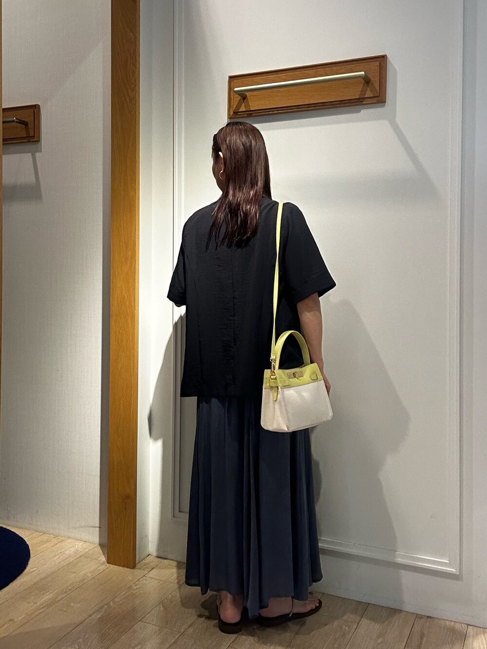 グレー系のテーラードジャケット、ホワイト系のTシャツ/カットソー、ブルー系のスカートを着用したレディースの夏コーディネートの3枚目の写真