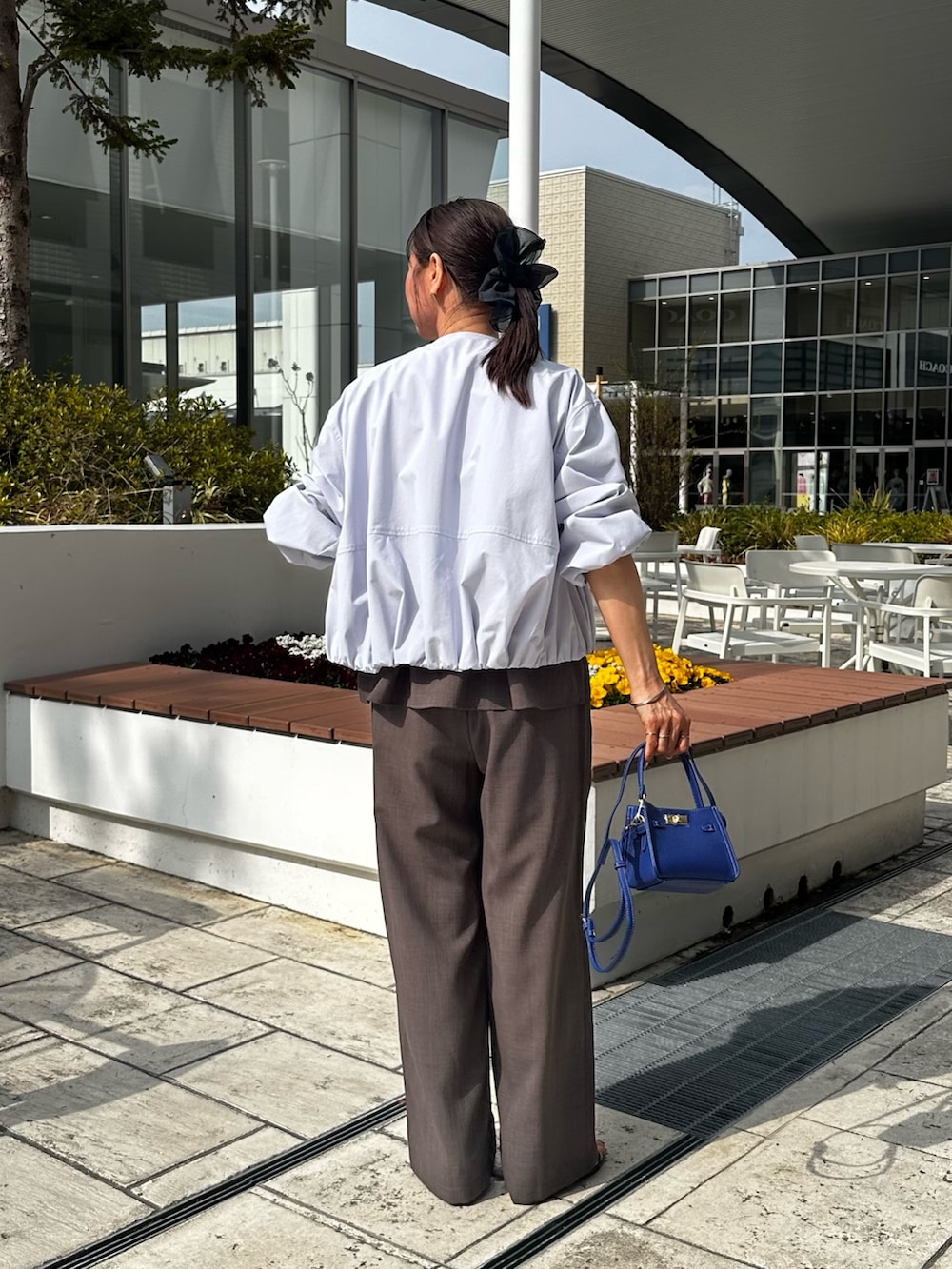 ブルー系のブルゾン、グリーン系のシャツ/ブラウス、ブルー系のショルダーバッグを着用したレディースの春コーディネートの3枚目の写真