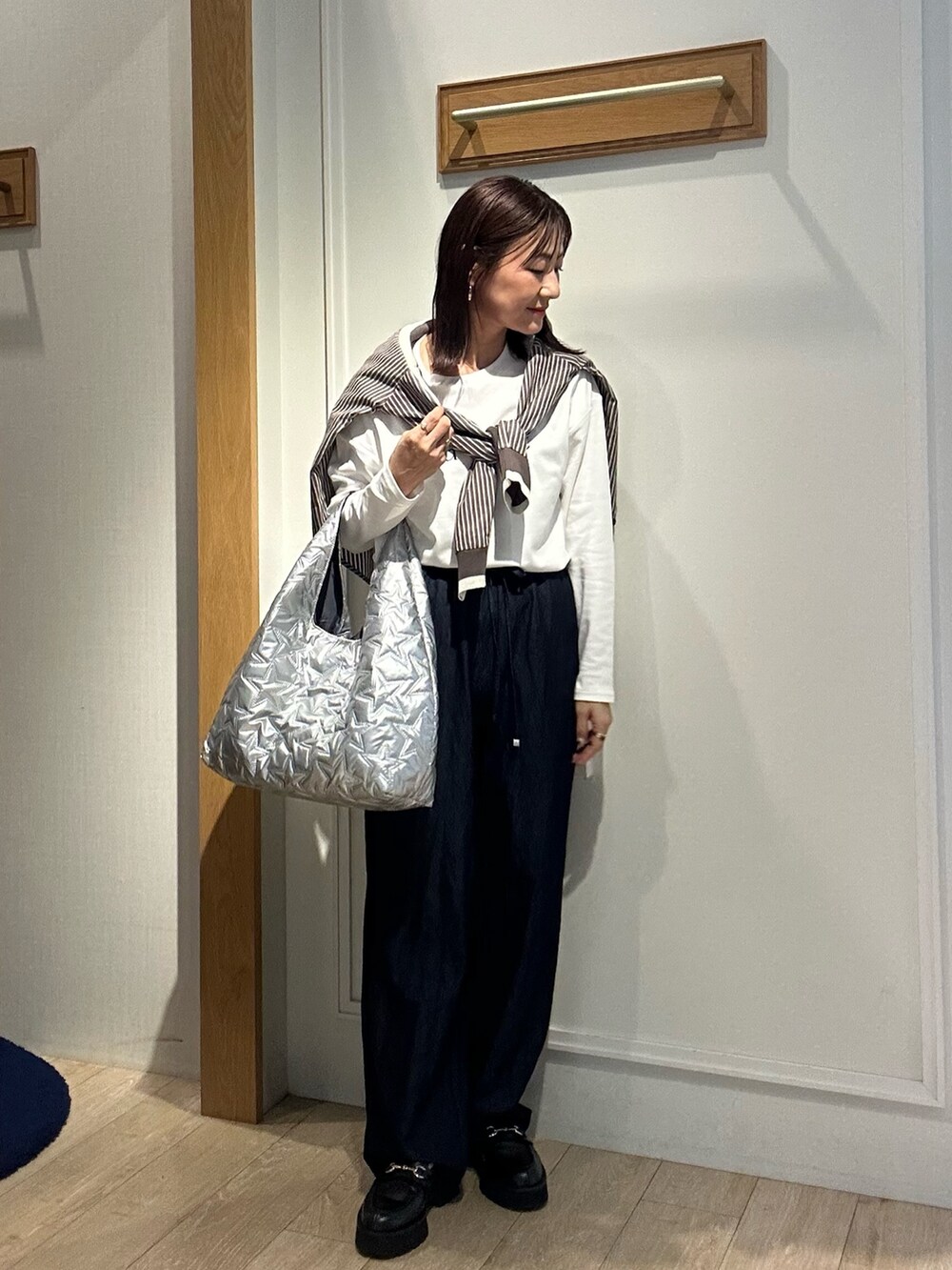 ブラウン系のシャツ/ブラウス、ブルー系のデニムパンツ、シルバー系のトートバッグを着用したレディースの秋コーディネートの6枚目の写真
