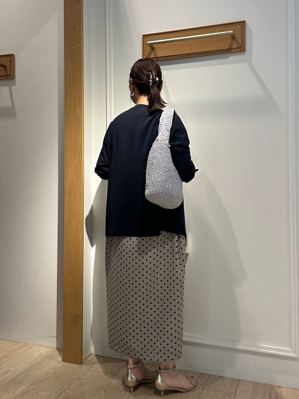 ベージュ系のワンピース、ブルー系のノーカラージャケットを着用したレディースの夏コーディネートの3枚目の写真