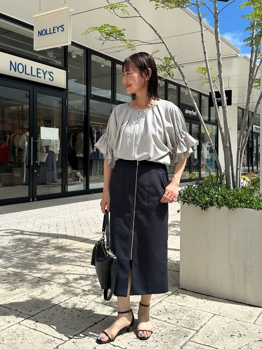 ブルー系のスカート、イエロー系のノーカラージャケット、ベージュ系のシャツ/ブラウスを着用したレディースの夏コーディネートの10枚目の写真